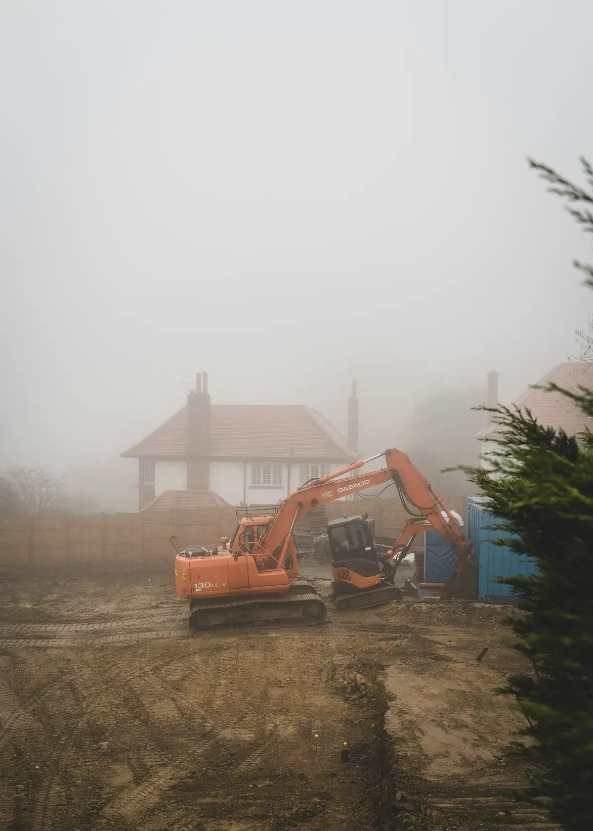 Excavator working on a plot in fog