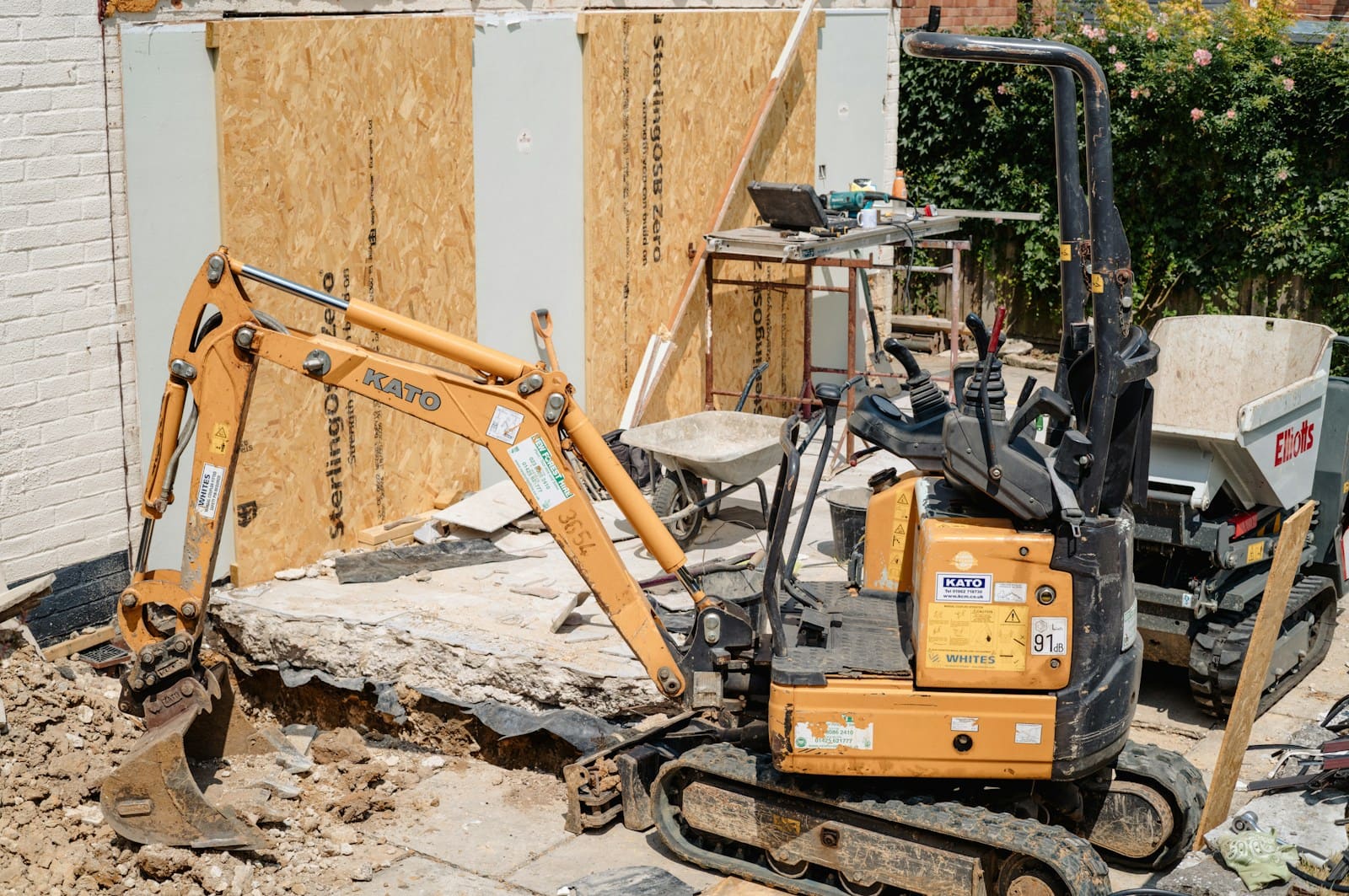 Micro digger working beside a house extension